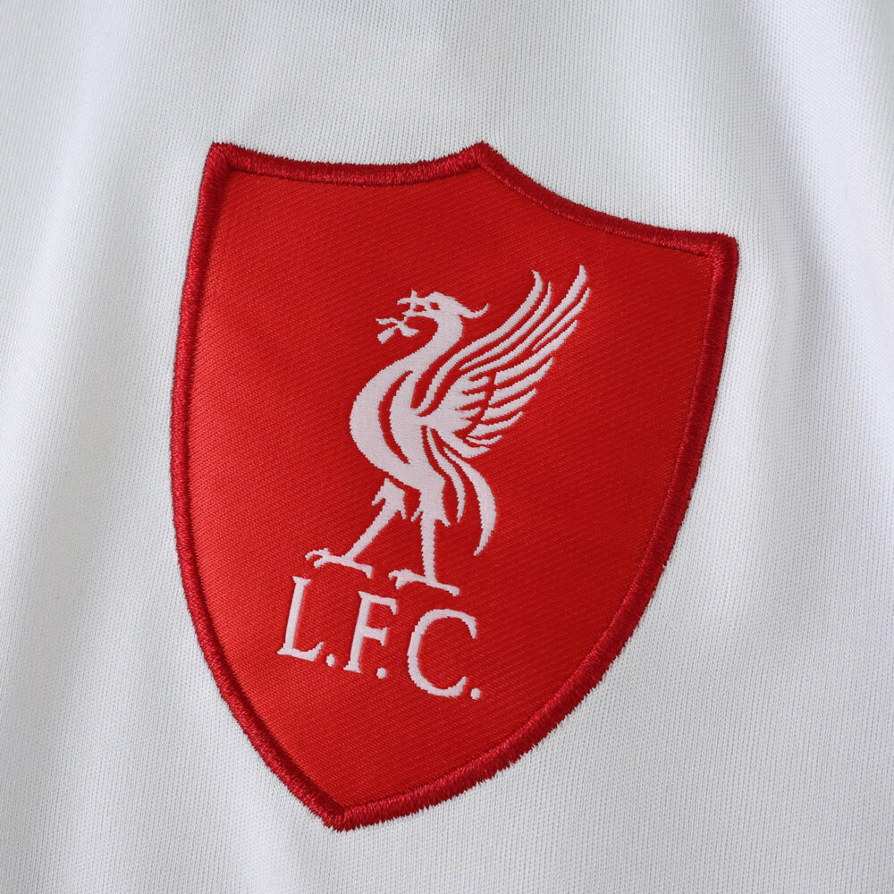 Close-up of Liverpool FC crest in red on the 2025/26 away fan version jersey.