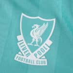 Close-up of the Liverpool FC crest on the teal 2025/26 Third player version football shirt.