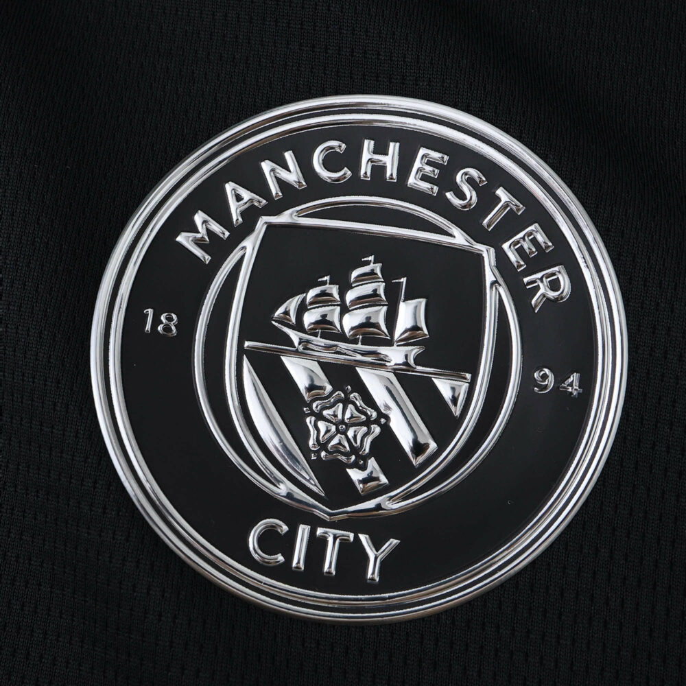 Manchester City 2025/26 away fan version badge featuring club crest in silver on black fabric.