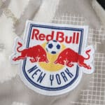Close-up of the New York Red Bulls 2025/26 away fan jersey crest on patterned fabric.