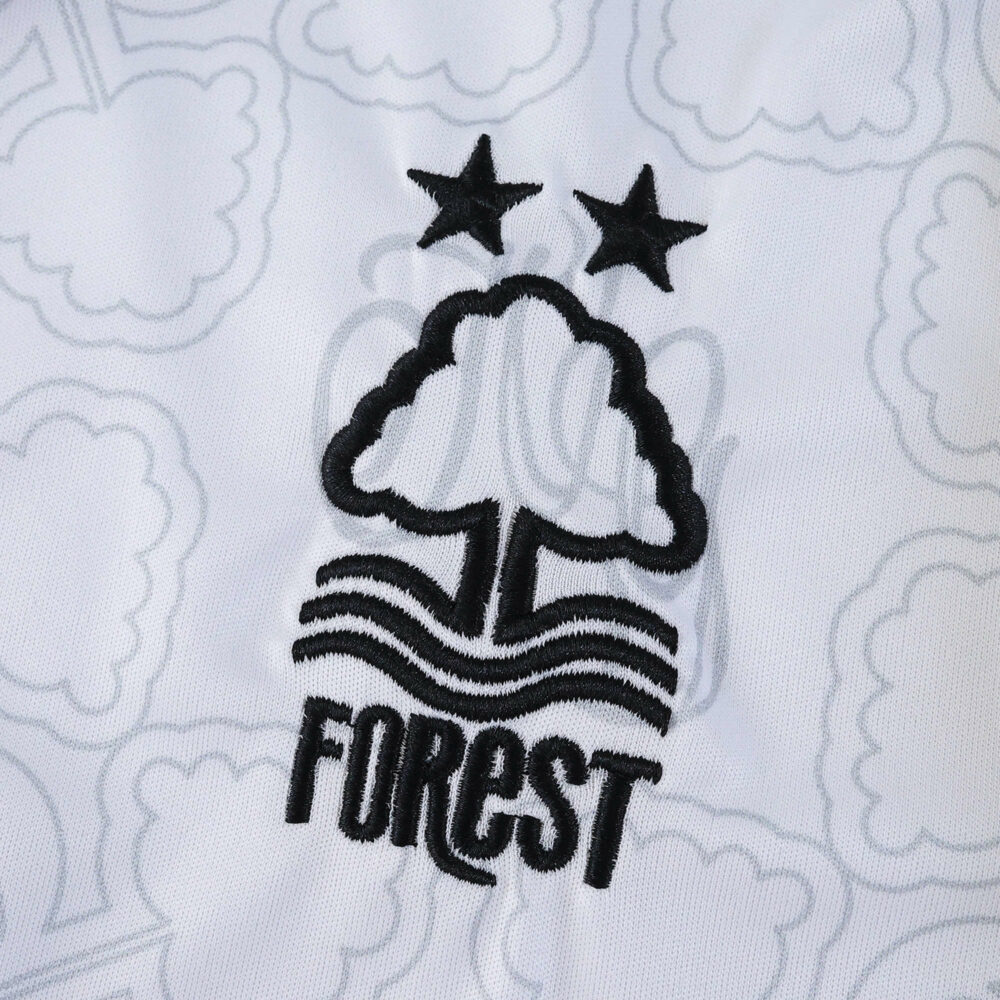 Nottingham Forest Away 2025/26 Fan Version crest with two stars on white patterned fabric.