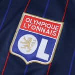 Olympique Lyonnais 2025/26 away fan version jersey featuring club crest on dark blue fabric with red stripes.