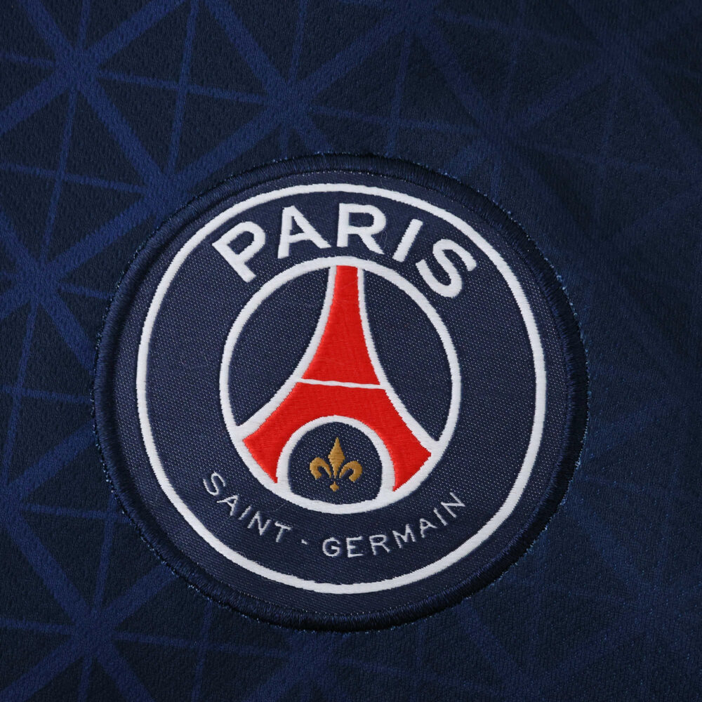 Close-up of the Paris Saint-Germain crest on the 2025/26 Home Fan Version jersey.