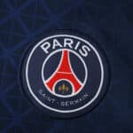 Close-up of the Paris Saint-Germain crest on the 2025/26 Home Fan Version jersey.