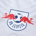 Close-up of the RB Leipzig crest on the 2025/26 home fan version jersey.