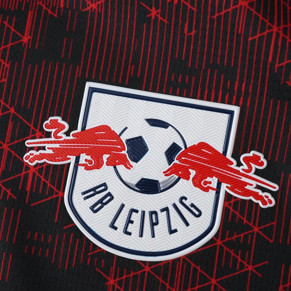 RB Leipzig logo on the 2025/26 third fan version jersey with a red and black patterned background.