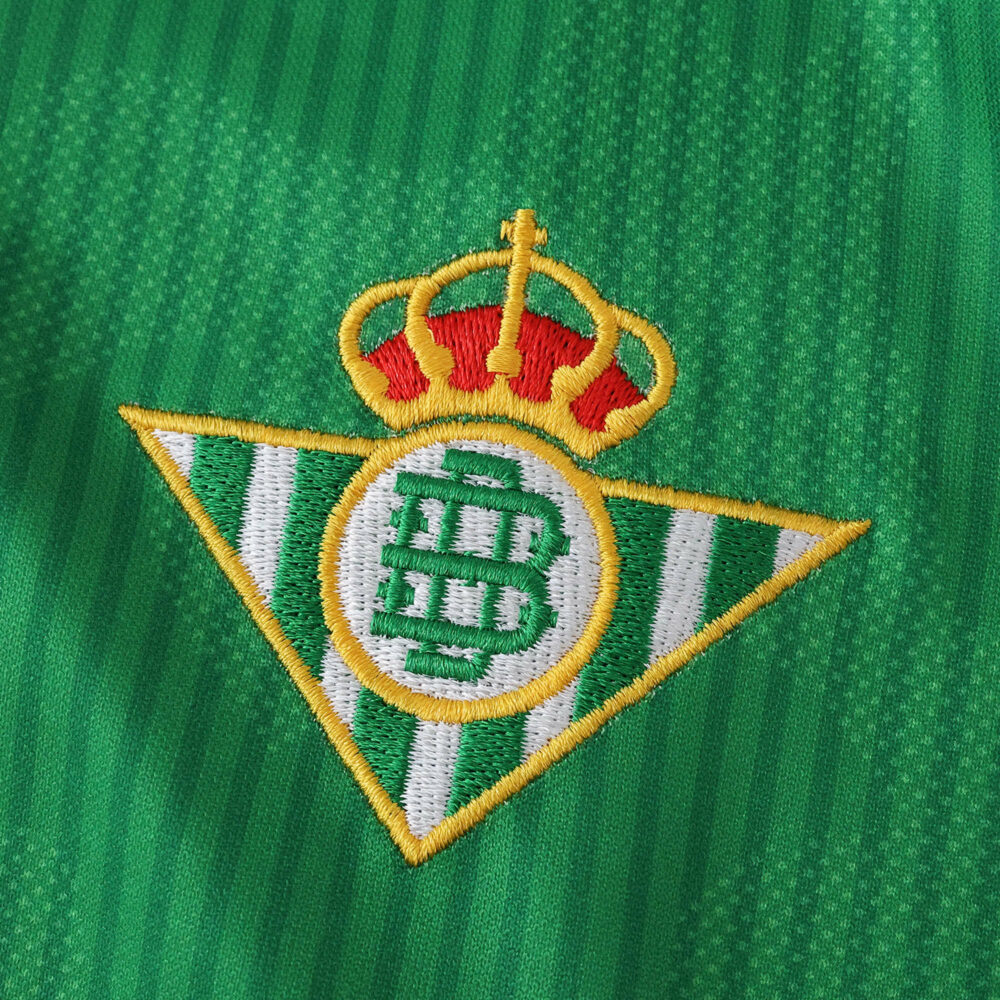 Close-up of the Real Betis crest on the green 2025/26 home fan version jersey.