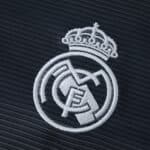 Close-up of the embroidered Real Madrid crest on the 2025/26 away fan version jersey.