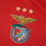 Close-up of the SL Benfica crest and three stars on the 2025/26 home jersey, Fan Version.
