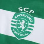 Close-up of the Sporting CP 2025/26 home jersey crest, featuring the club logo and green-white stripes.