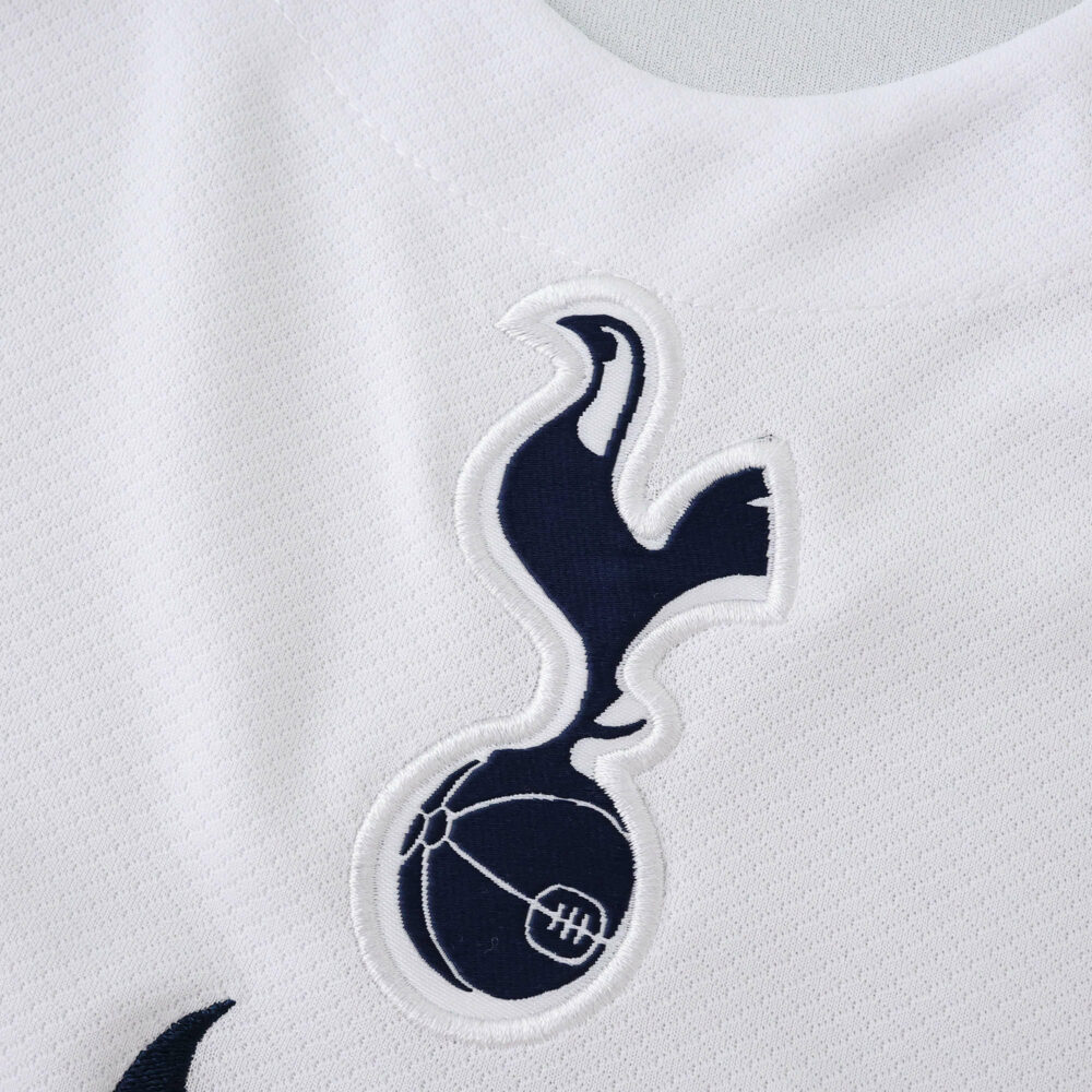 Close-up of the Tottenham Hotspur crest on the 2025/26 home fan version jersey.