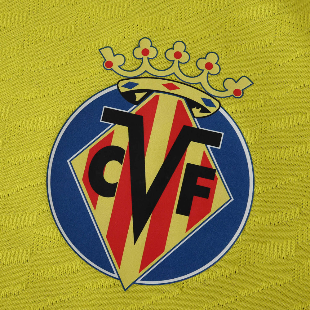 Close-up of Villarreal CF crest on the yellow 2025/26 home player version football shirt.