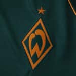 Close-up of Werder Bremen 2025/26 third fan version jersey with embroidered club crest and gold star.