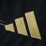 Close-up of the gold Adidas logo on the Aberdeen Away 2025/26 Fan Version jersey fabric.