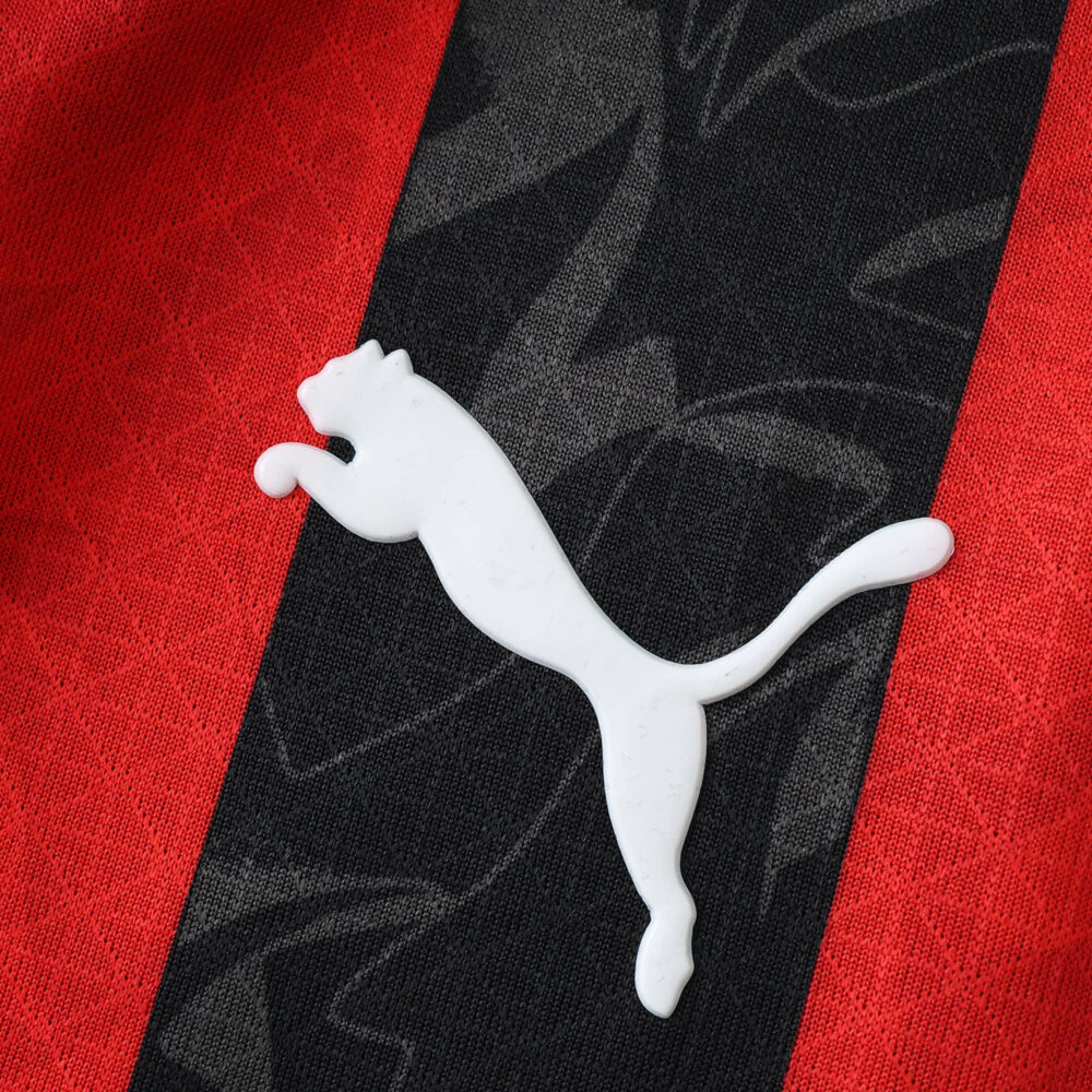 Close-up of the Puma logo on the AC Milan Home 2025/26 Player Version jersey's red and black stripes.