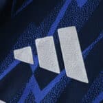 Close-up of the Adidas logo on the Arsenal Away 2025/26 Player Version jersey in blue and navy.