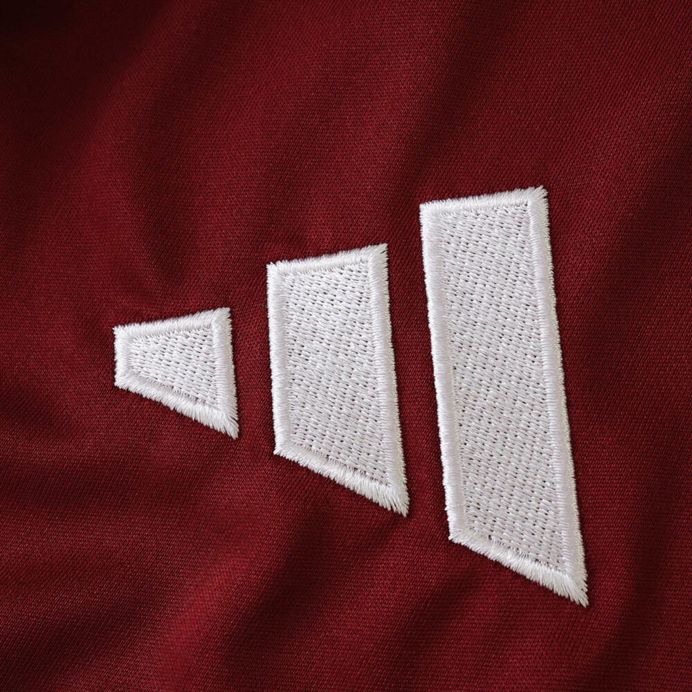 Close-up of the Aston Villa 2025/26 Home Fan Version jersey fabric featuring a white Adidas logo.