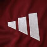 Close-up of the Aston Villa 2025/26 Home Fan Version jersey fabric featuring a white Adidas logo.