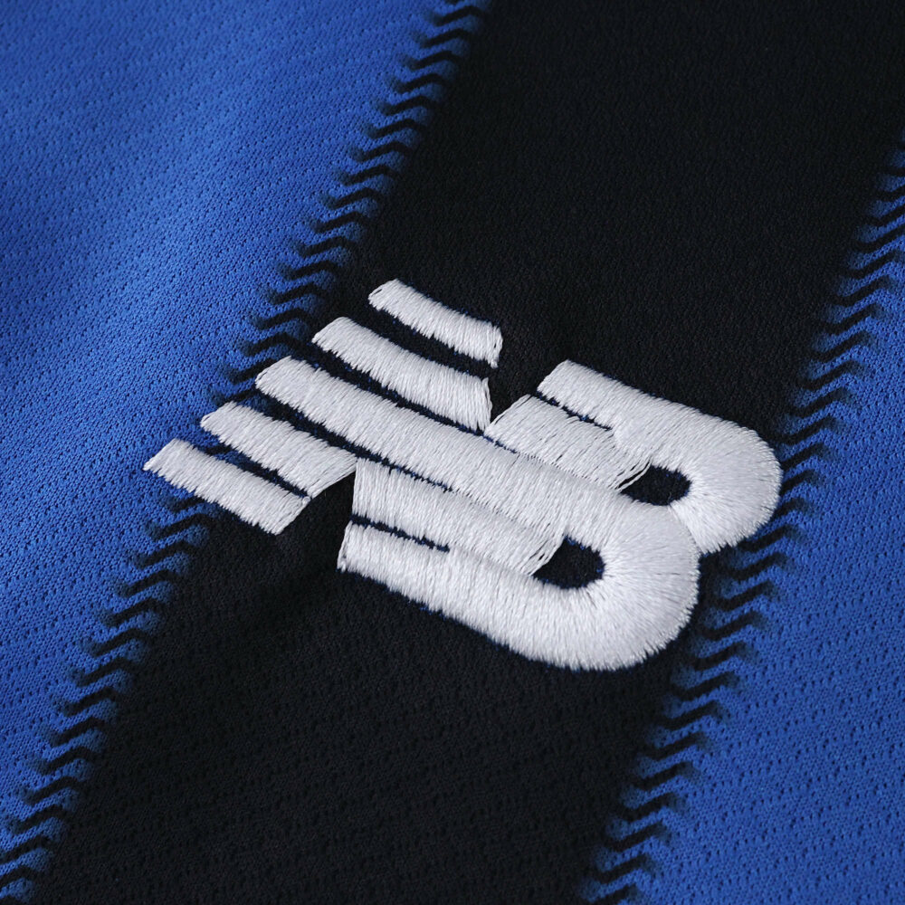 Close-up of the New Balance logo on the 2025/26 Atalanta Home Fan Version football jersey.