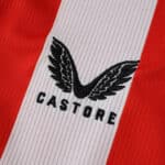 Close-up of the Castore logo on the Athletic Bilbao 2025/26 home fan jersey, red and white stripe background.