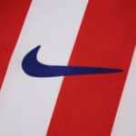 Close-up of the 2025/26 Atlético Madrid Home Fan jersey with Nike logo on red and white stripes.