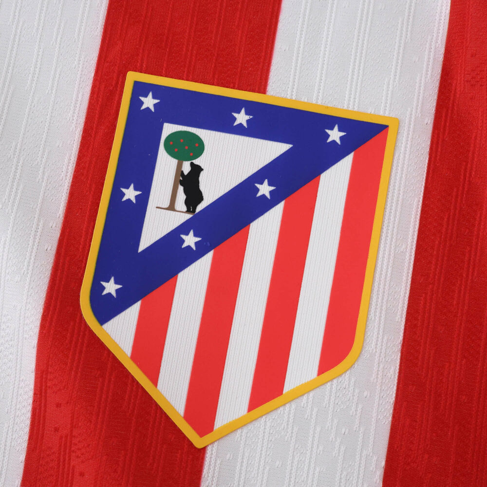 Atlético Madrid 2025/26 home jersey crest featuring red stripes and club badge on player version fabric.
