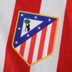 Atlético Madrid 2025/26 home jersey crest featuring red stripes and club badge on player version fabric.