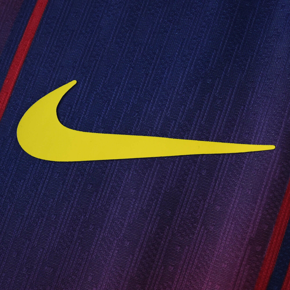Close-up of the yellow Nike logo on the 2025/26 Barcelona Home Player Version jersey fabric.