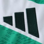 Close-up of the Celtic Home 2025/26 Fan Version jersey showcasing the stitched Adidas logo on green and white fabric.