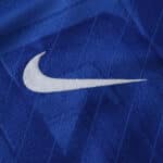 Close-up of the white Nike logo on the blue Chelsea Home 2025/26 Fan Version jersey fabric.