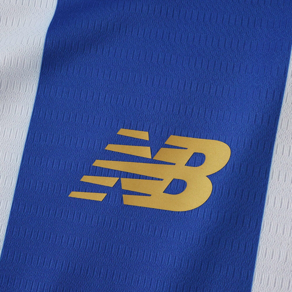 Close-up of the New Balance logo on the 2025/26 FC Porto home fan jersey with blue and white stripes.