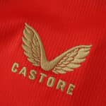 Gold Castore logo embroidered on the red Feyenoord Home 2025/26 Fan Version jersey fabric.