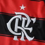 Close-up of the Flamengo 2025/26 home fan jersey featuring the club crest and a white star on red and black fabric.