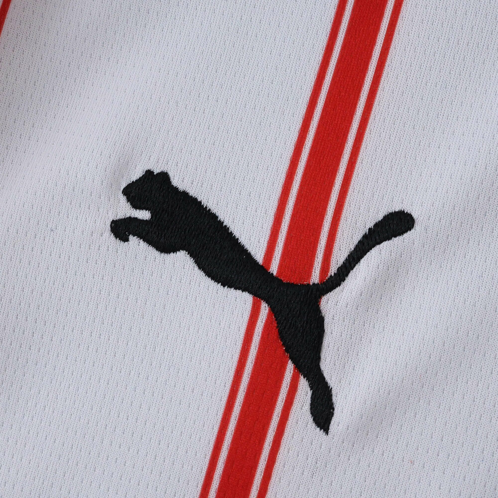 Close-up of Girona Home 2025/26 Fan Version jersey showing Puma logo and red stripes on white fabric.