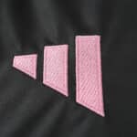 Close-up of the Inter Miami CF Away 2025/26 Fan Version jersey showing pink geometric logo stitching.