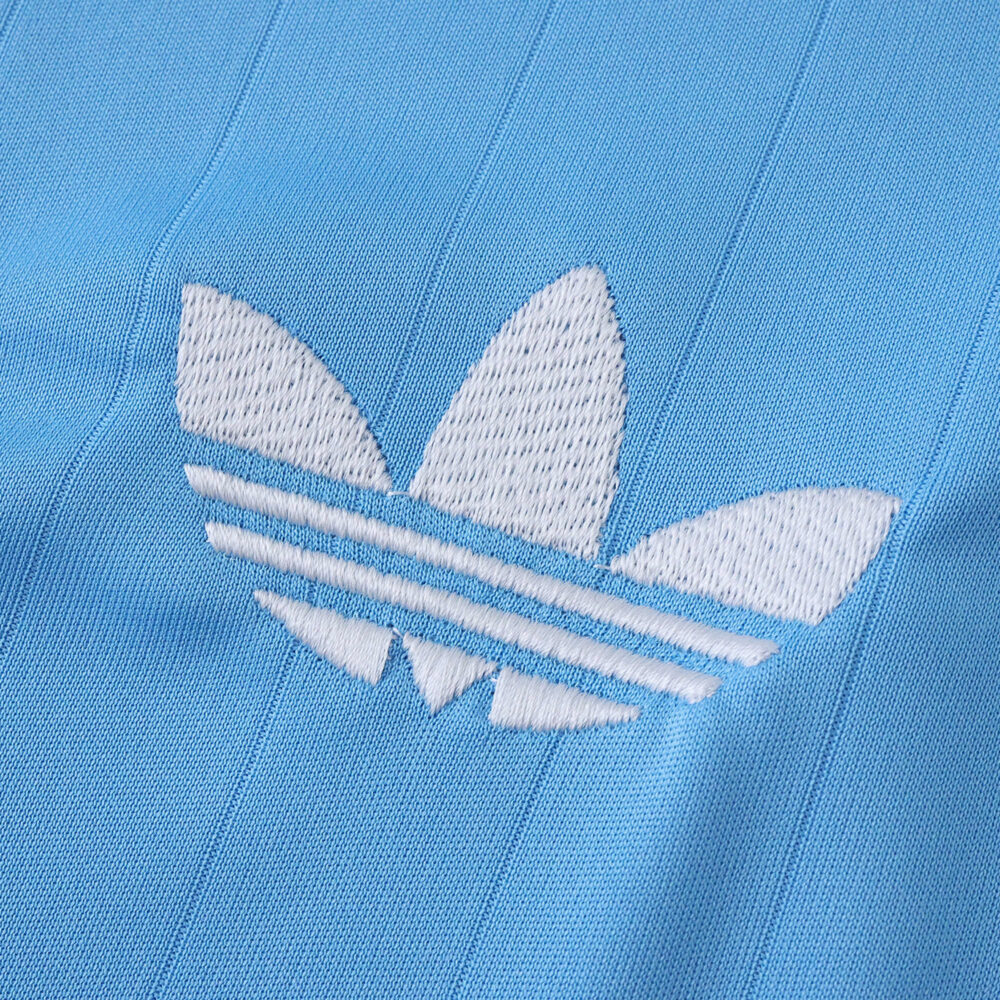 Close-up of the white Adidas Trefoil logo on the blue Inter Miami CF 2025/26 third fan jersey fabric.