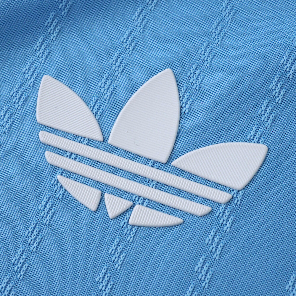 Close-up of the white Adidas Trefoil logo on the blue Inter Miami CF 2025/26 third player jersey fabric.