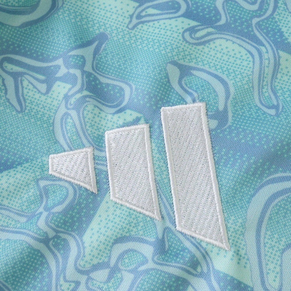 Close-up of the Juventus Away 2025/26 Fan Version jersey fabric with white Adidas logo on blue pattern.