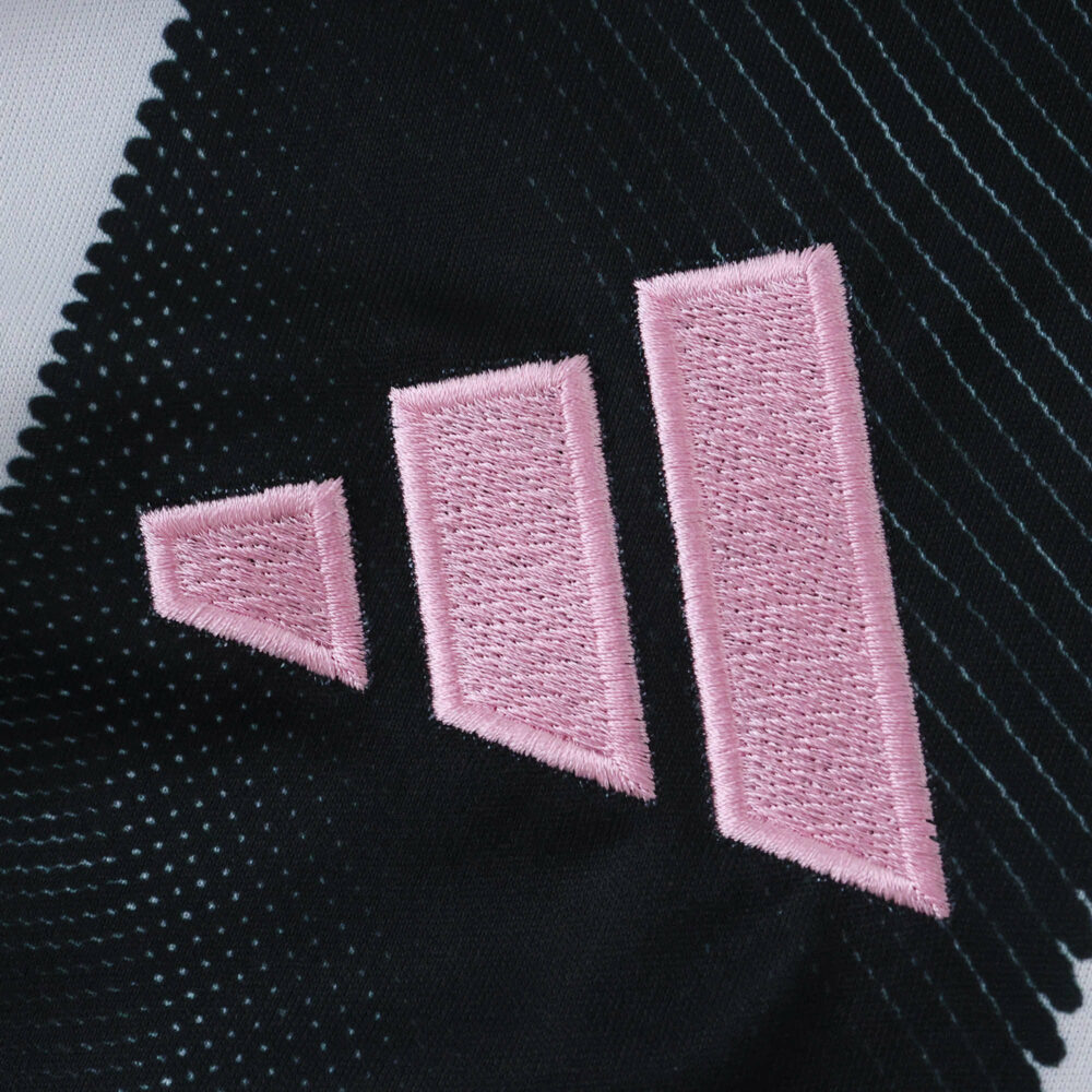 Close-up of pink Adidas logo on the Juventus 2025/26 Home Fan Version jersey fabric.