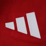 Close-up of the white adidas logo on the red Manchester United 2025/26 Home Player Version jersey.