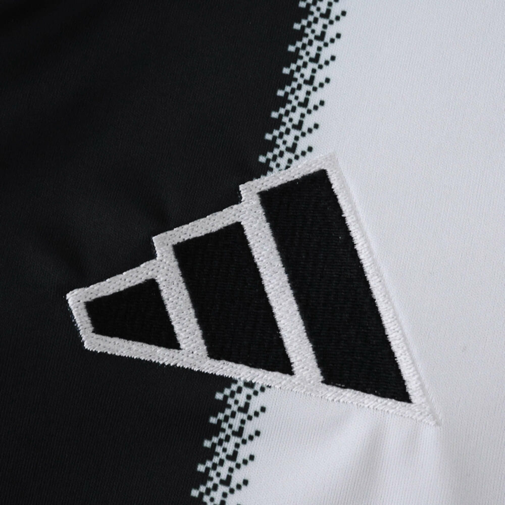 Close-up of the Newcastle United Home 2025/26 fan jersey featuring the Adidas logo on black and white fabric.