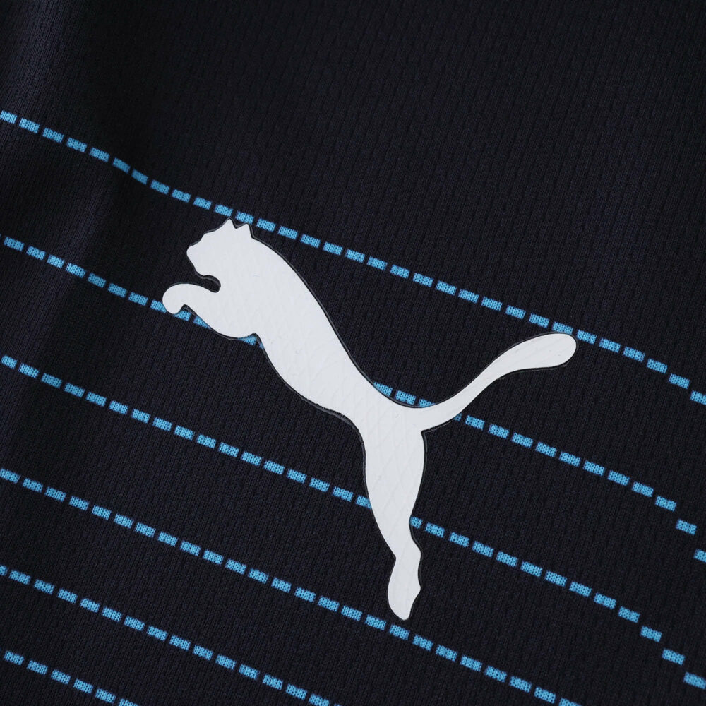 Close-up of the Puma logo on the Olympique Marseille 2025/26 Away Fan Version jersey with blue stripes.
