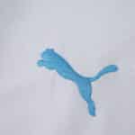 Close-up of the blue Puma logo on the Olympique Marseille 2025/26 Home Fan Version jersey fabric.