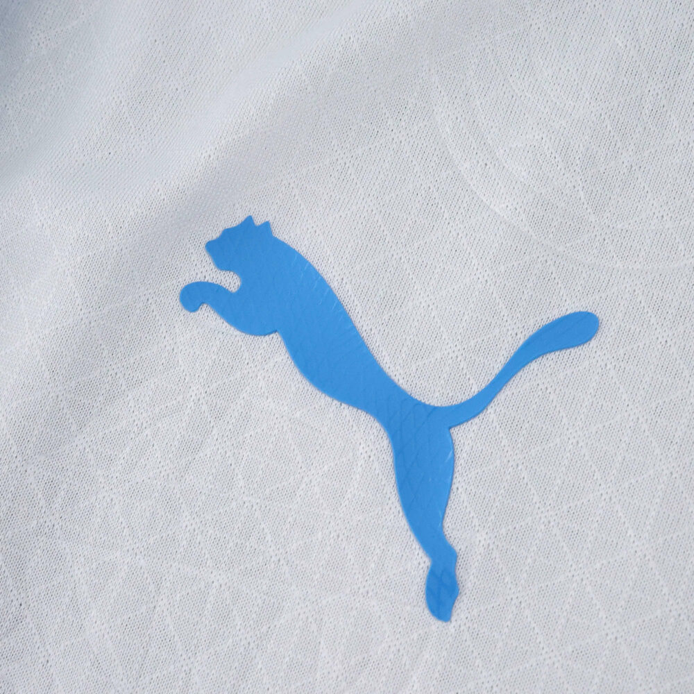 Close-up of blue Puma logo on the Olympique Marseille 2025/26 Home Player Version jersey fabric.