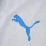 Close-up of blue Puma logo on the Olympique Marseille 2025/26 Home Player Version jersey fabric.