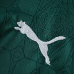 Close-up of the Puma logo embroidered on the green Palmeiras 2025/26 home fan jersey.
