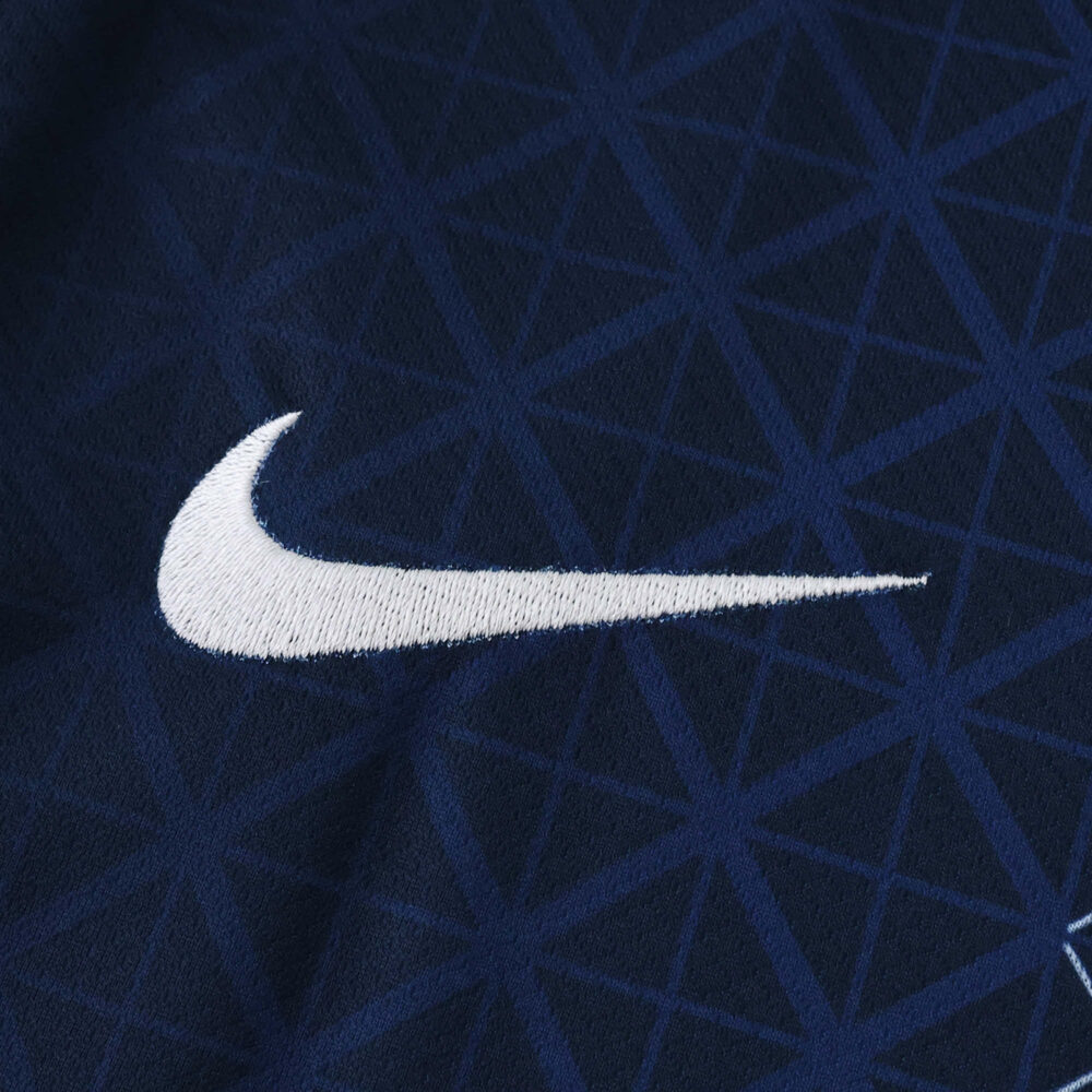 Close-up of the Nike logo on the Paris Saint-Germain 2025/26 Home Fan Version jersey, navy with geometric pattern.