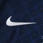 Close-up of the Nike logo on the Paris Saint-Germain 2025/26 Home Fan Version jersey, navy with geometric pattern.