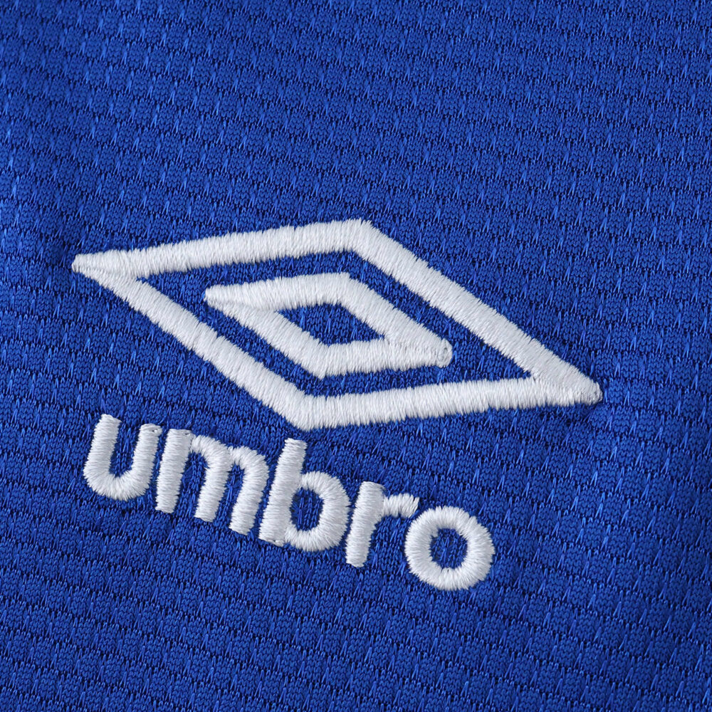 Close-up of the Umbro logo embroidered on the blue Rangers Home 2025/26 Fan Version jersey fabric.