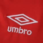 Close-up of the white Umbro logo on the red Rangers Third 2025/26 Fan Version jersey fabric.